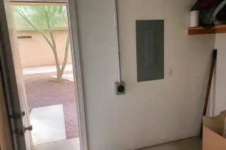 NEMA 14-50 outlet with conduit installed on a wall near an open door in a Phoenix, AZ home.