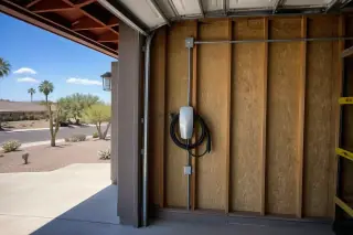 Wall-mounted EV charger with conduit installed inside a garage in Phoenix, AZ.