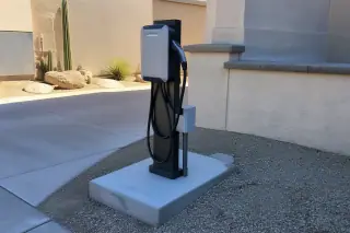 Level 2 EV charger on a concrete pedestal at a private driveway in Phoenix, AZ.