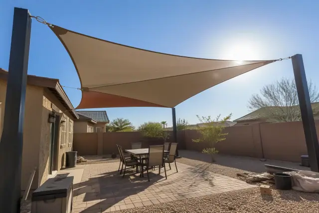 Rectangular patio shade sail tensioned between steel posts in an open courtyard in Gilbert, AZ.