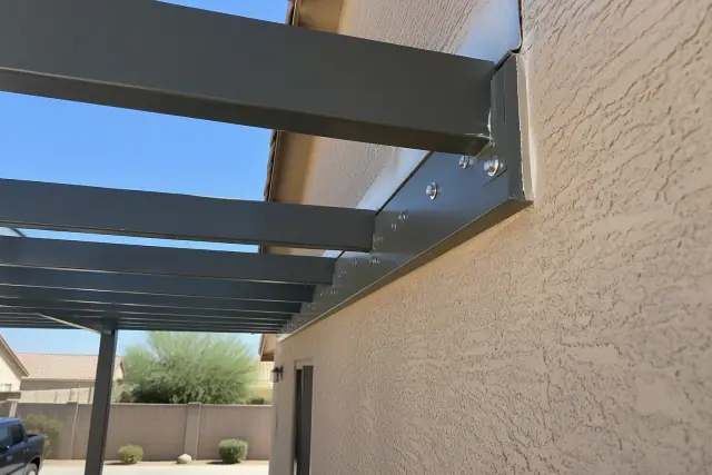 Attached carport ledger connection with heavy-duty lag bolts and flashing on a Gilbert, AZ home exterior wall.
