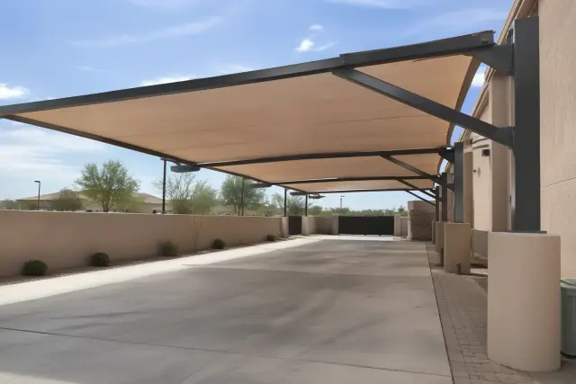 Cantilever shade structure with an offset steel frame and fabric canopy over a concrete loading zone in Gilbert, AZ.