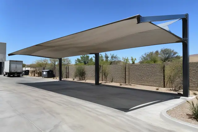 Cantilever shade structure with fabric canopy and offset steel frame over a concrete loading zone in Queen Creek, AZ.