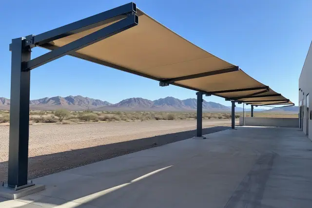 Cantilever shade structure with steel frame and fabric canopy over a concrete loading zone in Apache Junction, AZ.