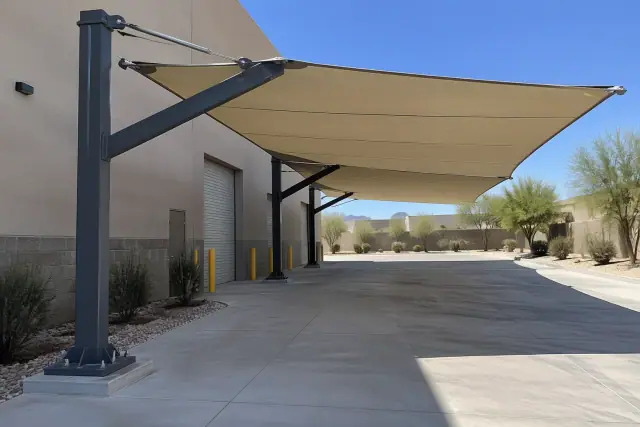 Cantilever shade structure with fabric canopy and steel frame over a concrete loading zone in Scottsdale, AZ.