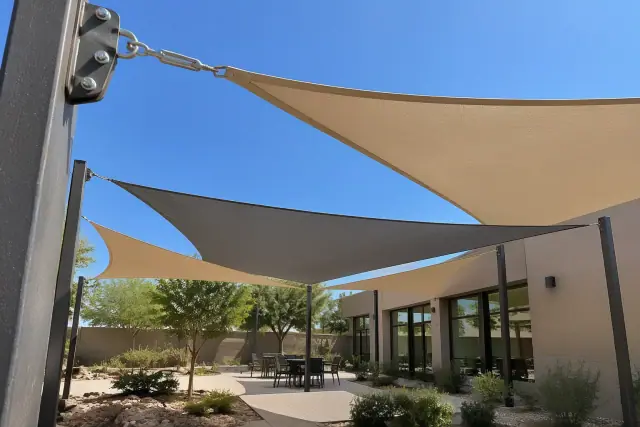 Triangle shade sail tensioned to steel posts above a desert courtyard in Gilbert, AZ.