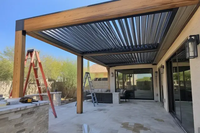 Adjustable aluminum louvered roof installation on timber beams over a travertine patio in Gilbert, AZ.