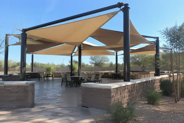 Tensioned membrane shade structure and ramada over a stamped concrete patio in Gilbert, AZ.