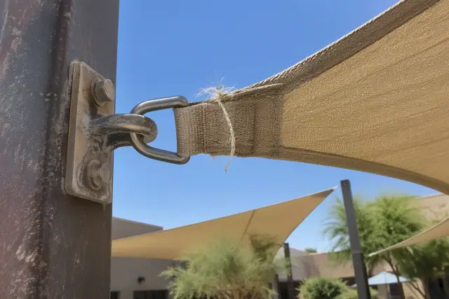 Frayed stitching on a shade sail D-ring webbing loop in Gilbert, AZ.