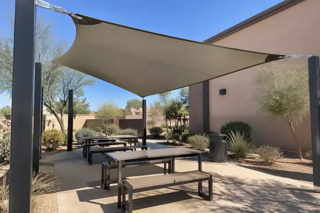 HDPE tension-fabric shade structure installed over an outdoor seating pavilion in Gilbert, AZ.