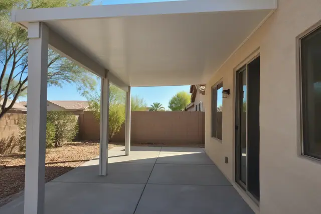 Insulated aluminum patio cover on a home in Gilbert, AZ, showing solid roof panels and aluminum posts.
