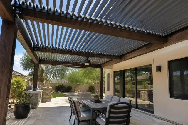 Louvered roof installation with adjustable aluminum blades on timber beams above a stone patio in Chandler, AZ.