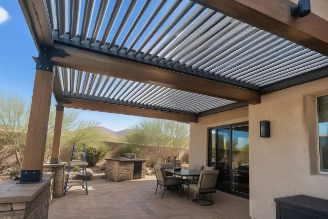Louvered roof installation on a timber frame over a stone patio in Mesa, AZ.