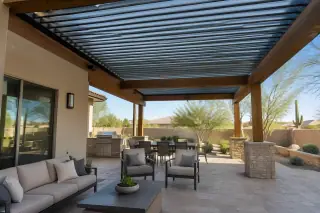 Adjustable aluminum louvered roof installed on a timber frame above a stone patio in Gilbert, AZ.