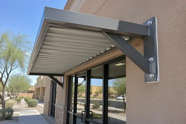 Metal awning installation above a commercial storefront entrance in Tempe, AZ.