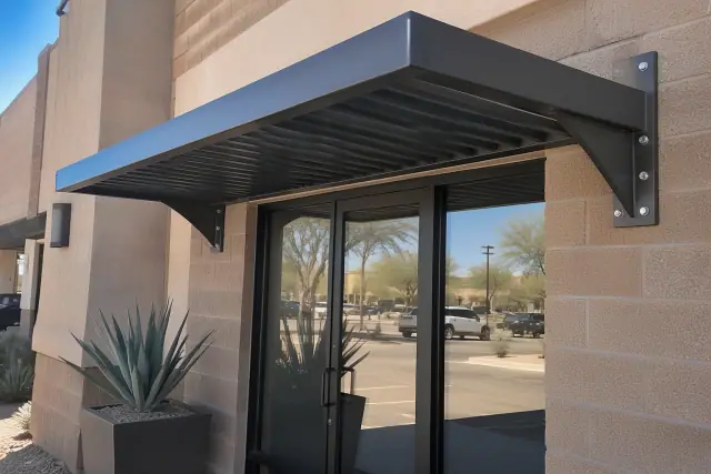 Metal awning installation above a commercial storefront entrance in Mesa, AZ.
