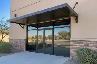 Extruded aluminum canopy mounted on an exterior brick wall above a commercial storefront in Gilbert, AZ.