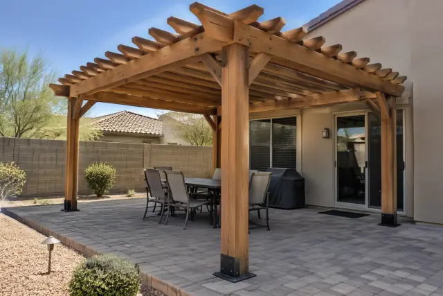 Freestanding wood rafter pergola over paver stones at a backyard patio in Gilbert, AZ.