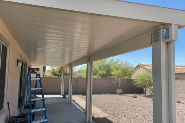 Patio cover installation with solid insulated roof panels on aluminum posts in Phoenix, AZ.