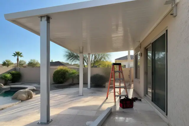 Patio cover installation with aluminum brackets bolted to a slab in Scottsdale, AZ.