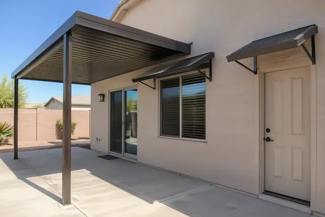 Metal awnings installed over windows and doors on a home patio in Gilbert, AZ.