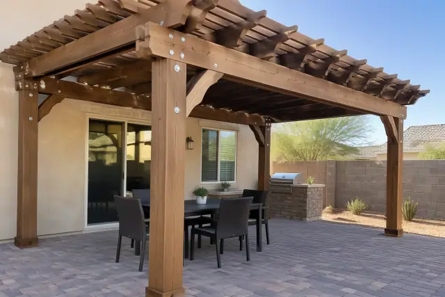 Freestanding wood rafter pergola installed over a backyard paver deck in Chandler, AZ.