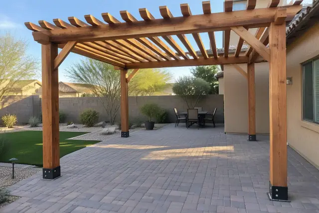 Freestanding wood pergola installed over a backyard paver deck with metal post brackets in Tempe, AZ.