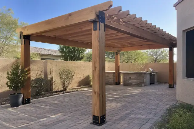 Pergola installation with wood rafters and metal brackets over paver stones in Mesa, AZ.