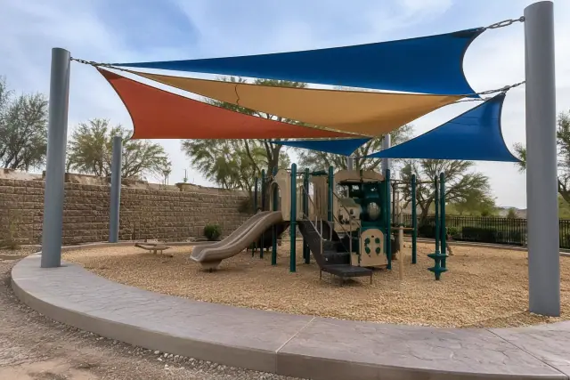 Playground shade sail installation with multi-colored fabric and steel columns in Gilbert, AZ.