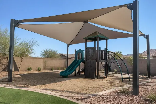 Multi-sail curved hip canopy installed over a residential playground in San Tan Valley, AZ.