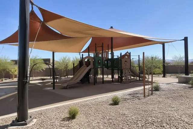 Curved hip sail shade structure installed over a modern playground in Tempe, AZ.