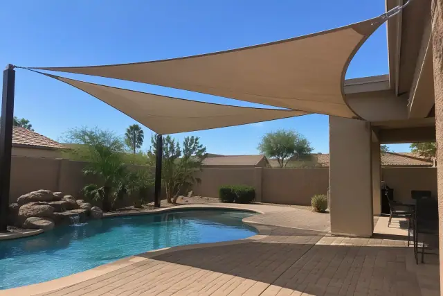 Pool shade sails installed over paver decking in a backyard in Gilbert, AZ.