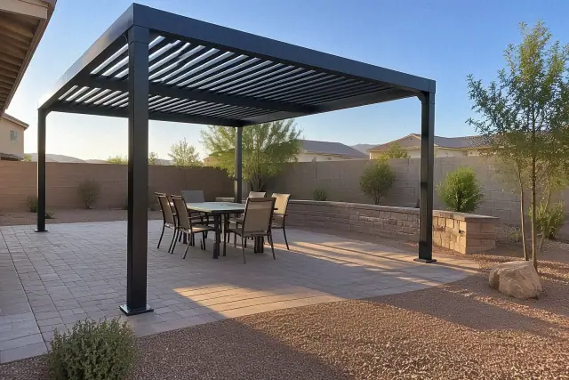 Powder-coated aluminum pergola installed over a stone patio in Gilbert, AZ, with a retaining wall.