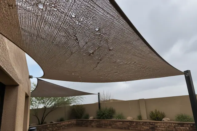 Rain dripping through a knitted patio shade sail in Gilbert, AZ.