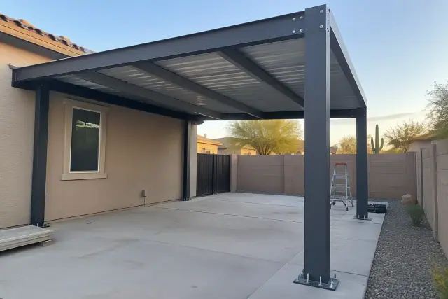 Residential carport installation with exposed anchor bolts and steel purlins in Gilbert, AZ.