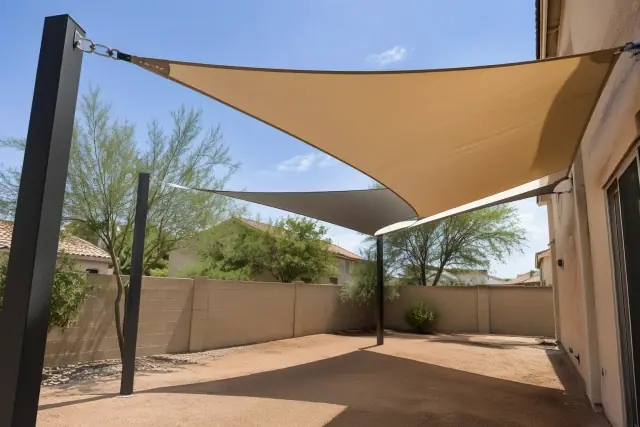 Shade sail installation with tensioned fabric membranes over a courtyard in Tempe, AZ.
