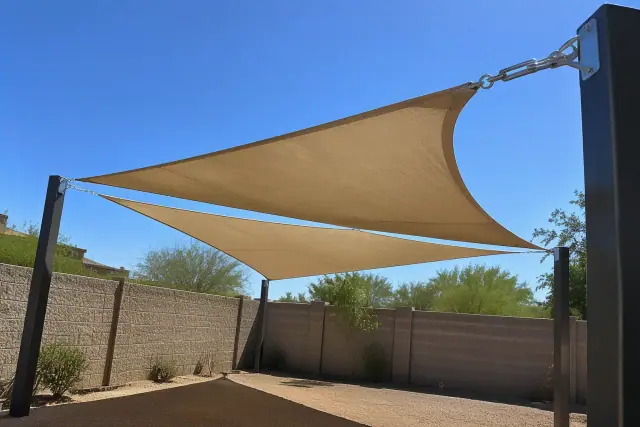 Shade sail installation with tensioned fabric membranes and steel posts in a Chandler, AZ courtyard.