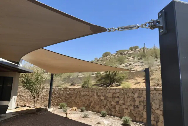 Shade sail installation with tensioned fabric and steel brackets in Paradise Valley, AZ.
