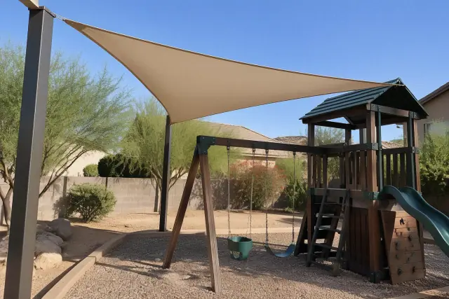 Triangular shade sail installed over a backyard swing set at a residential home in Gilbert, AZ.