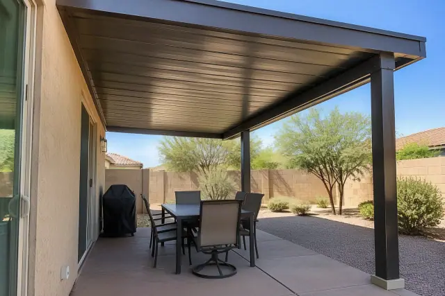 Solid metal pergola roof over a patio dining area at a home in Gilbert, AZ.
