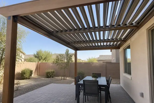 Solid patio cover with adjustable aluminum louvers on timber beams at a home in Gilbert, AZ.