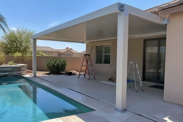Solid-roof ramada assembly with raw brackets beside a backyard pool in Gilbert, AZ.