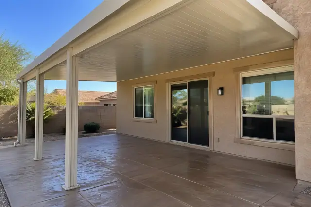 Completed vinyl patio cover installation with insulated panels and aluminum brackets in Gilbert, AZ.