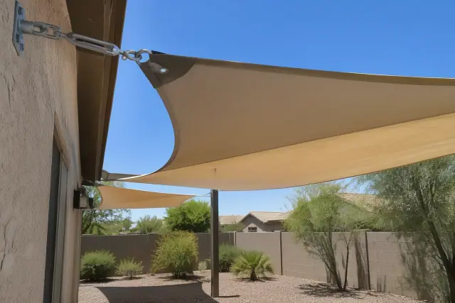 Waterproof PVC-coated shade sail installed on a residential stucco wall in Gilbert, AZ.