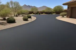 Technician cleaning tools near a finished smooth asphalt driveway with desert mountains in Goodyear, AZ.