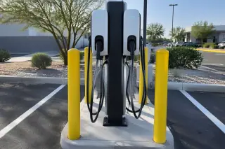 Dual-port commercial EV charging station on a concrete island in Mesa, AZ.