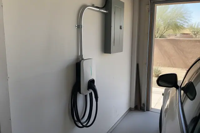 Contractor photo of EV charger panel upgrades with conduit on a drywall wall in Tempe, AZ.