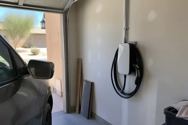 Wall-mounted EV charger installation on a drywall interior in Phoenix, AZ.