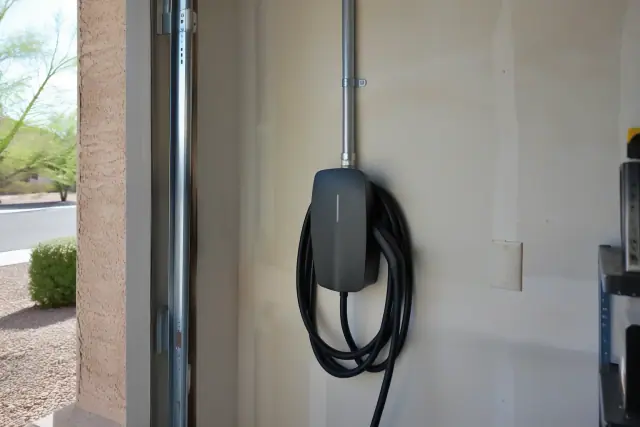 Hardwired EV charger installation on an interior wall with metal conduit in Mesa, AZ.