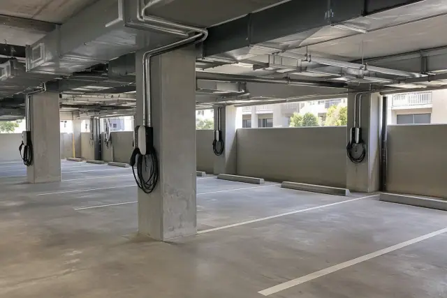 EV charger installation at an apartment complex in Chandler, AZ, showing wall-mounted units and overhead conduit.